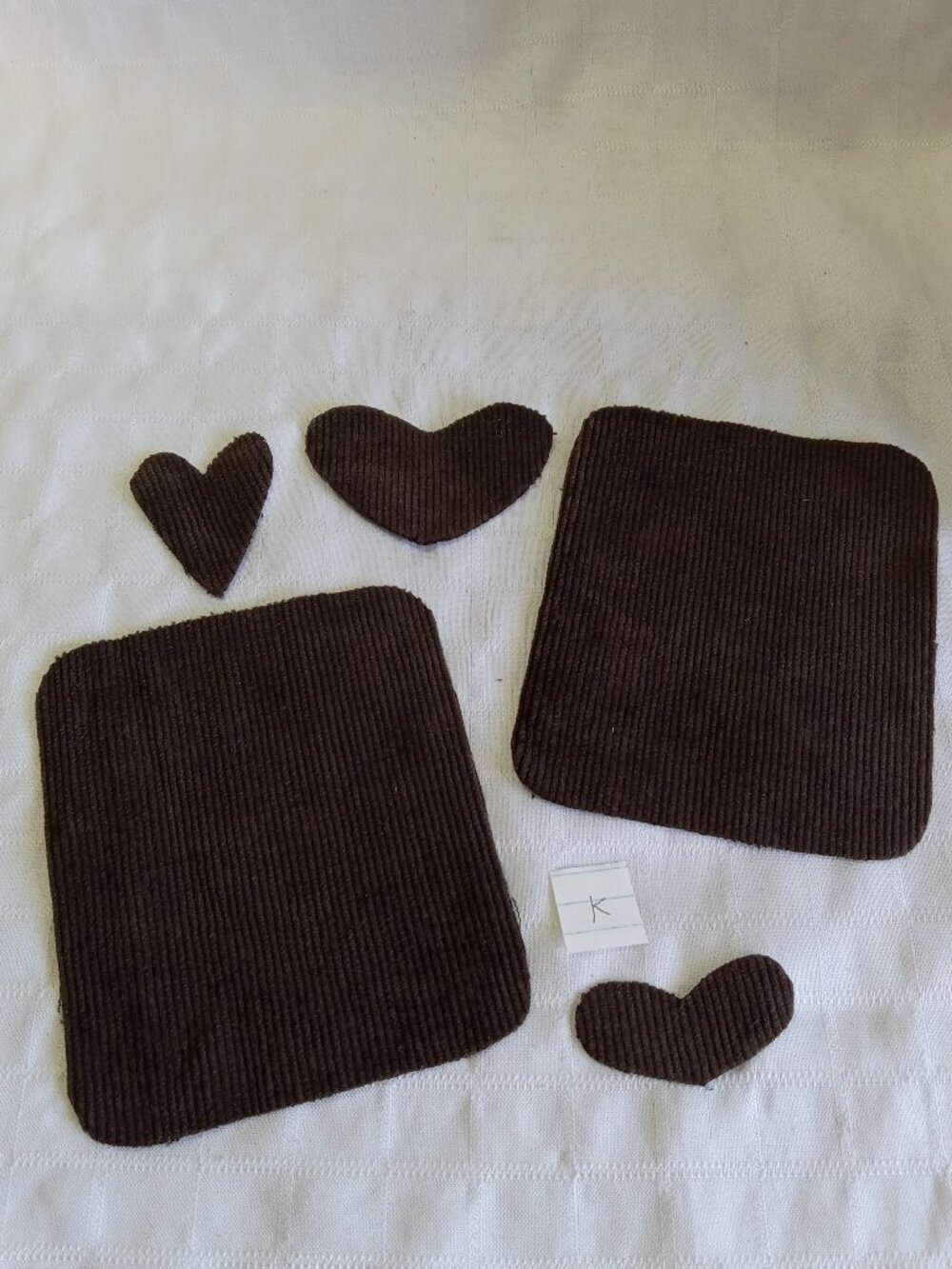 Two handmade elbow patches for sewing made of brown corduroy with hearts